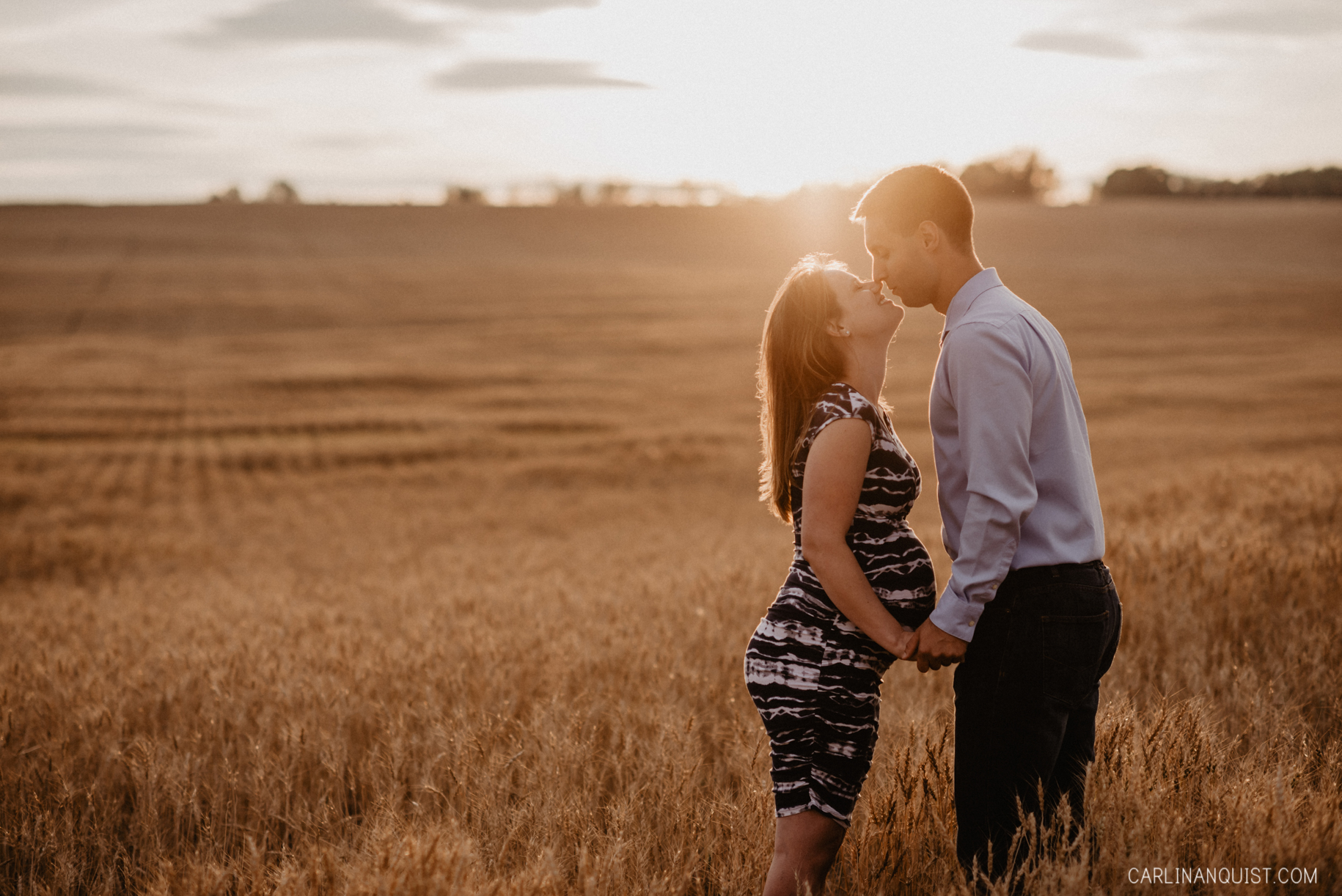 Pregnant Couple Kissing in Sunlight